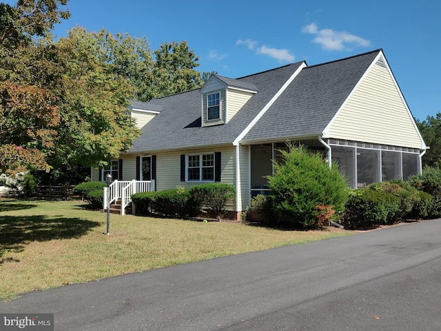 new england style home with a sunroom and a front lawn