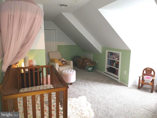 bedroom with vaulted ceiling, carpet floors, and a nursery area