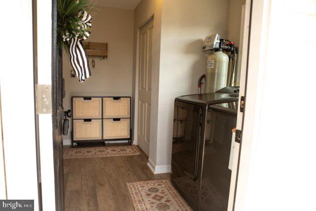 hall with washing machine and dryer and dark hardwood / wood-style flooring