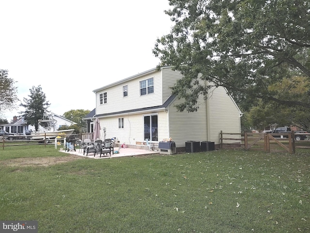 back of property featuring a lawn, cooling unit, and a patio