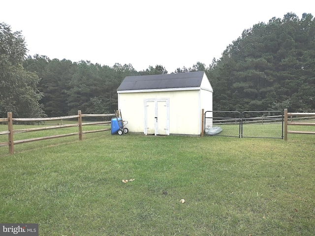 view of outdoor structure featuring a lawn and a rural view