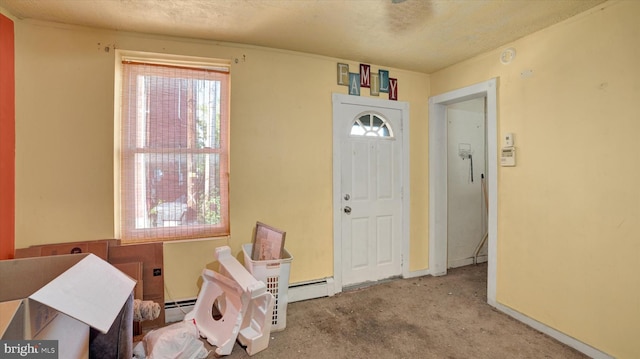 carpeted foyer entrance with a textured ceiling and baseboard heating