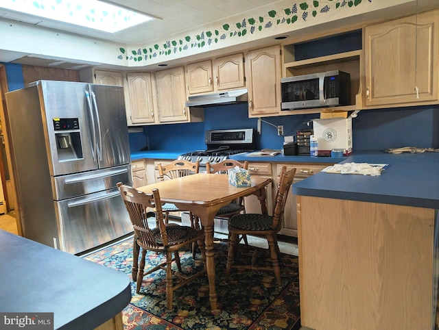 kitchen featuring light brown cabinets, a skylight, and appliances with stainless steel finishes