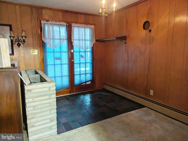 entryway with crown molding, wooden walls, an inviting chandelier, and a baseboard radiator