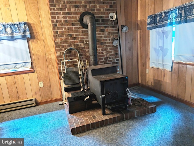 interior space with carpet, wood walls, a wood stove, and a wealth of natural light