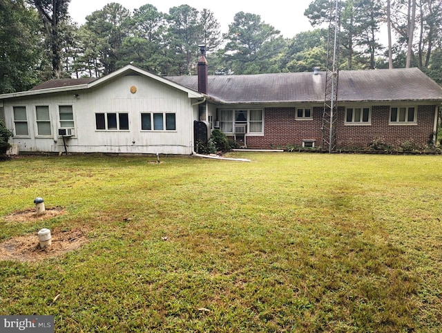 ranch-style home with cooling unit and a front lawn