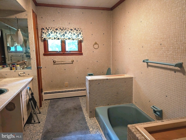 bathroom featuring tile walls, vanity, baseboard heating, crown molding, and a tub