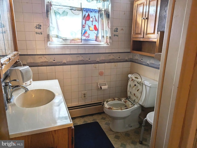 bathroom with vanity, tile patterned floors, a baseboard radiator, tile walls, and toilet