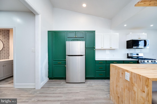 kitchen featuring light hardwood / wood-style flooring, vaulted ceiling, butcher block counters, and appliances with stainless steel finishes