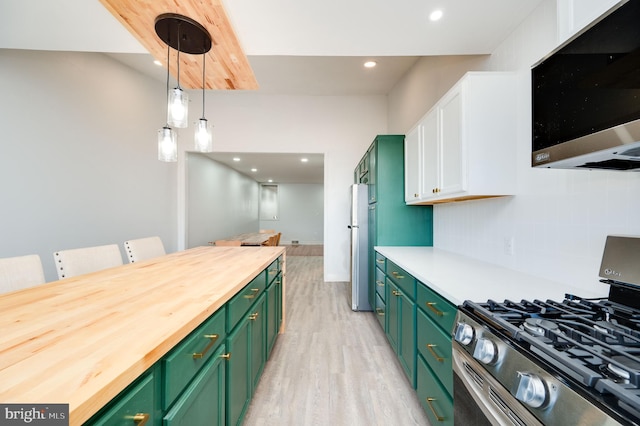 kitchen featuring pendant lighting, green cabinets, appliances with stainless steel finishes, and wooden counters