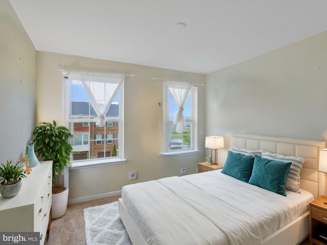 bedroom with light colored carpet and multiple windows