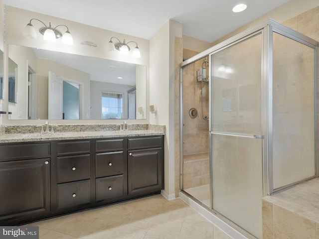 bathroom with tile patterned floors, a shower with shower door, and vanity