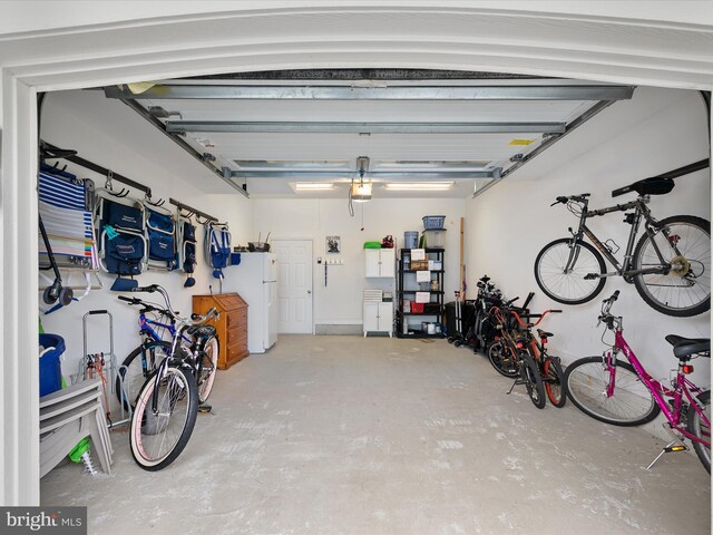 garage with a garage door opener and white fridge