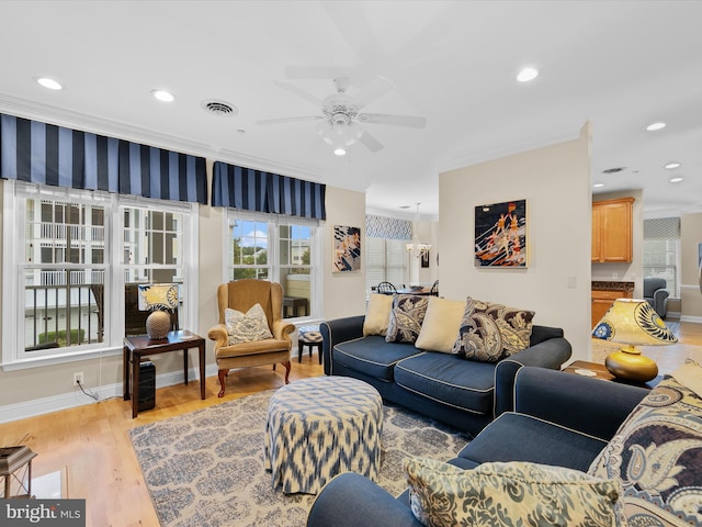 living room featuring light wood-type flooring, ornamental molding, and ceiling fan