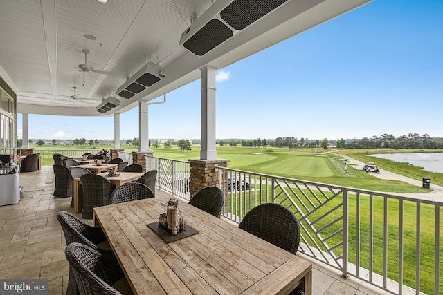 view of patio with a water view and ceiling fan