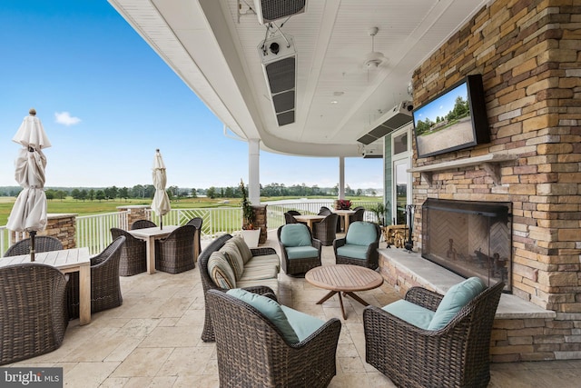 view of patio with an outdoor living space with a fireplace