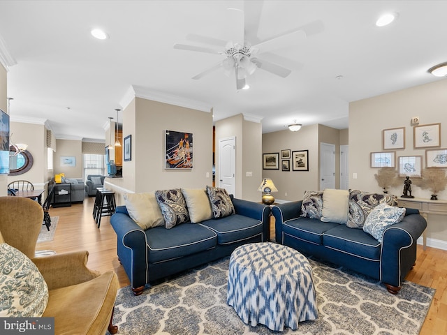 living room featuring ceiling fan, hardwood / wood-style flooring, and crown molding