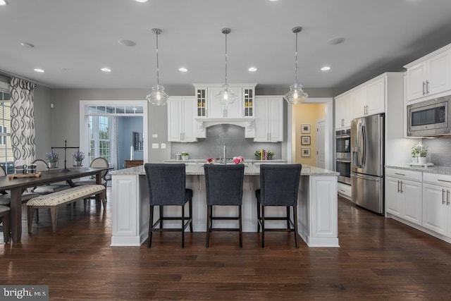 kitchen featuring pendant lighting, white cabinetry, appliances with stainless steel finishes, and dark wood-type flooring