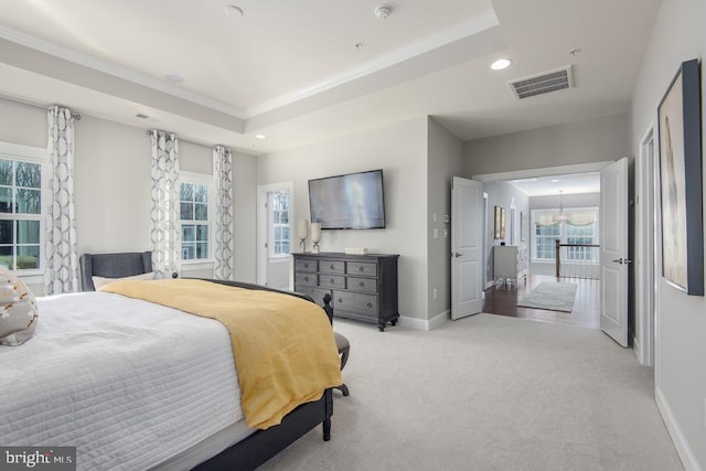 bedroom featuring light carpet and a tray ceiling