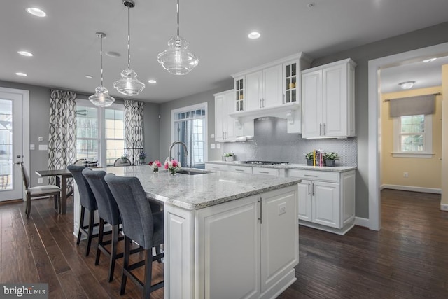 kitchen featuring white cabinets, decorative light fixtures, dark wood-type flooring, and a healthy amount of sunlight