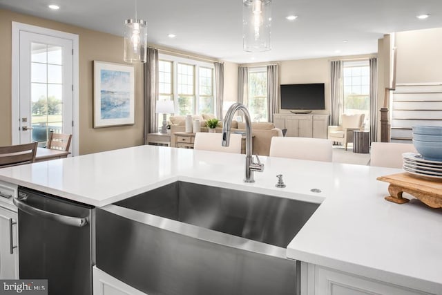 kitchen featuring dishwasher, white cabinetry, decorative light fixtures, and sink