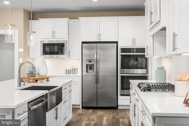 kitchen featuring white cabinetry, stainless steel appliances, and decorative light fixtures