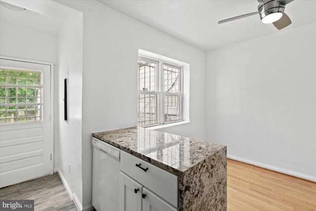 413 36th St NE, Washington, DC 20019 - kitchen featuring a ceiling fan, stone countertops, a peninsula, white dishwasher, and light wood-style flooring