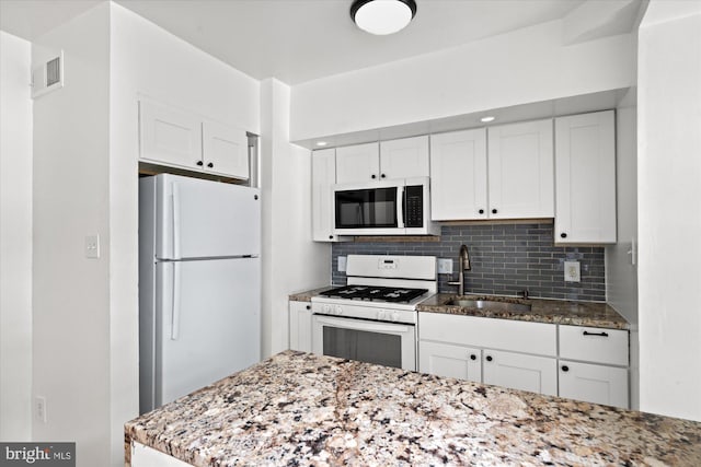 413 36th St NE, Washington, DC 20019 - kitchen with white appliances, white cabinetry, tasteful backsplash, and a sink