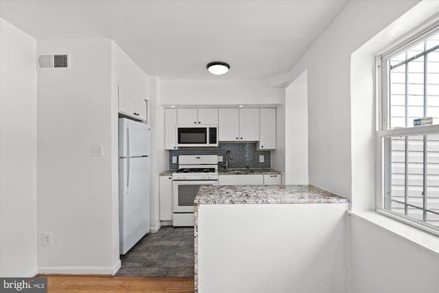 kitchen featuring white appliances, dark hardwood / wood-style floors, sink, and white cabinets