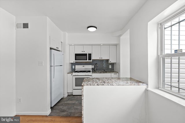 413 36th St NE, Washington, DC 20019 - kitchen with a sink, white cabinetry, white appliances, visible vents, and decorative backsplash
