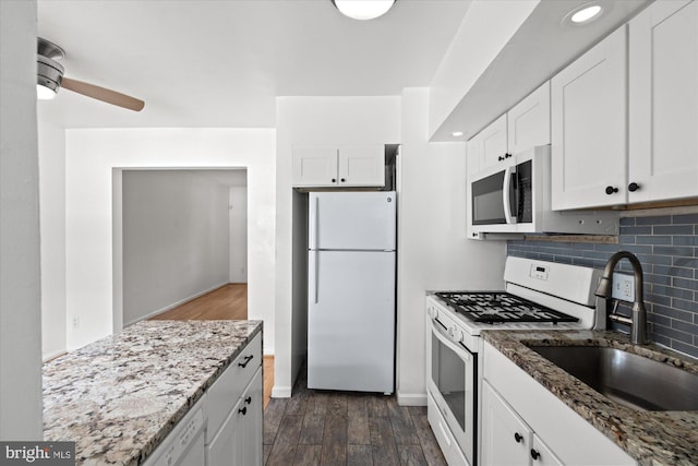 kitchen featuring white appliances, white cabinetry, dark wood-type flooring, and sink