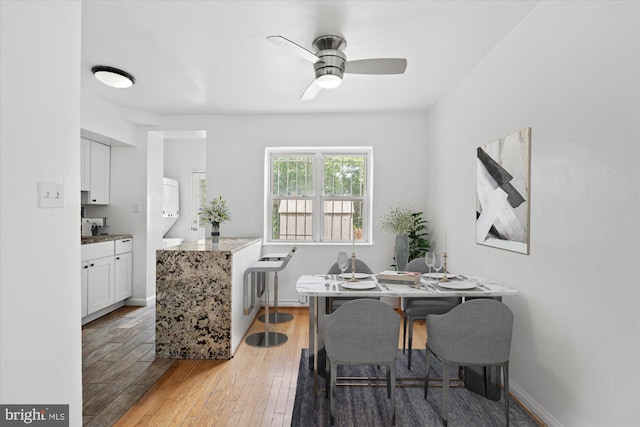 dining area with hardwood / wood-style floors and ceiling fan