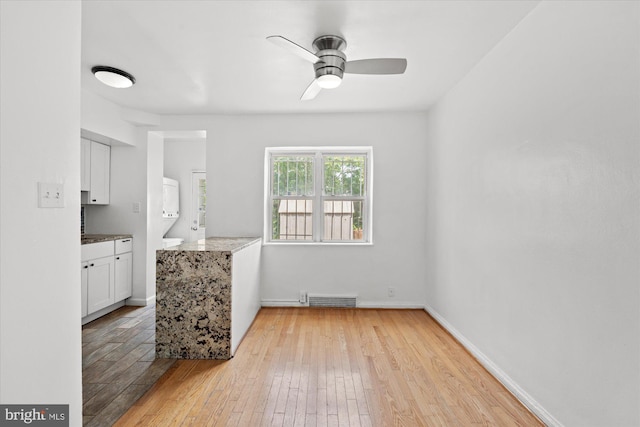 empty room with ceiling fan and light wood-type flooring