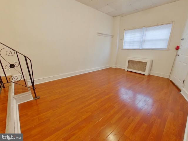 interior space with hardwood / wood-style floors and radiator heating unit