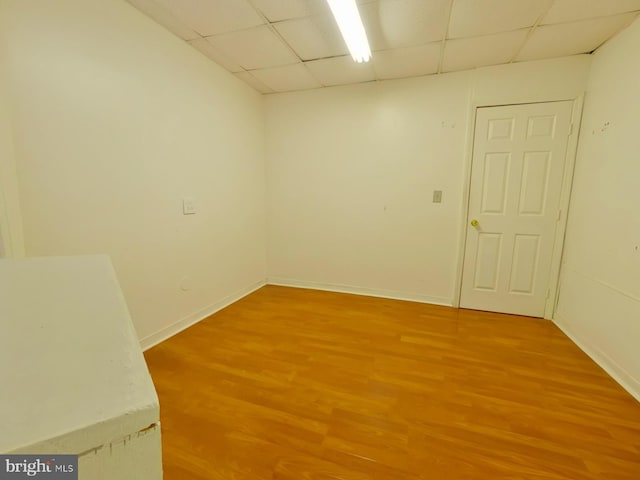 unfurnished room featuring a drop ceiling and hardwood / wood-style floors