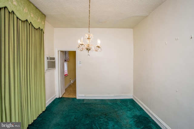 unfurnished dining area featuring a textured ceiling, an inviting chandelier, dark colored carpet, and a wall mounted AC