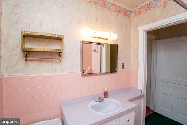 bathroom with tile walls, vanity, and toilet