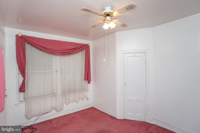 unfurnished room with ceiling fan and carpet