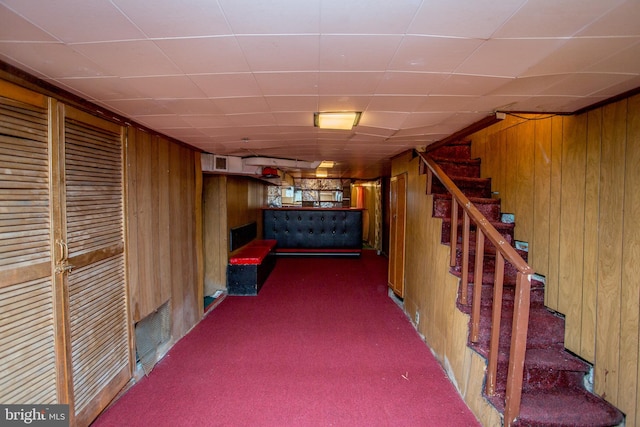 basement with dark carpet and wood walls