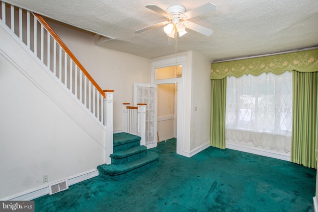 carpeted entryway featuring ceiling fan and a textured ceiling