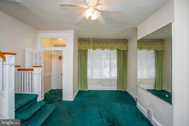 unfurnished room with ceiling fan, a textured ceiling, and dark colored carpet