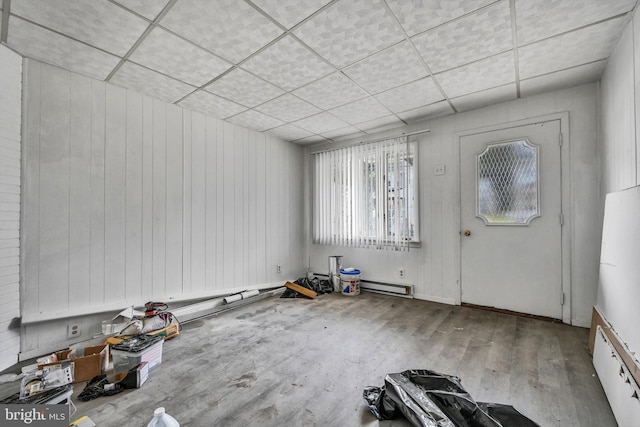 foyer with a paneled ceiling, wood walls, and hardwood / wood-style flooring