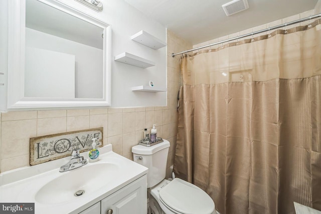 bathroom with tile walls, vanity, toilet, and a shower with shower curtain