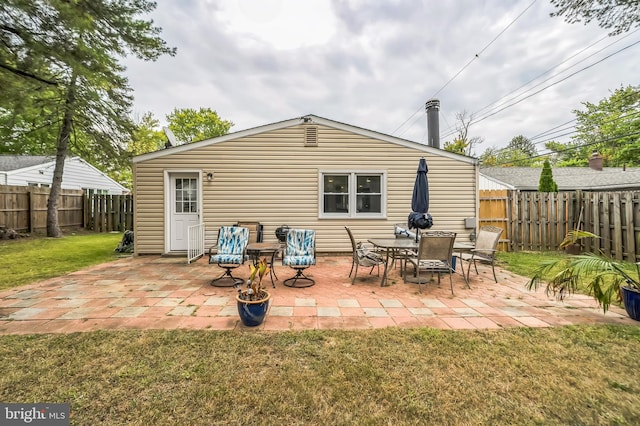 rear view of property featuring a lawn and a patio