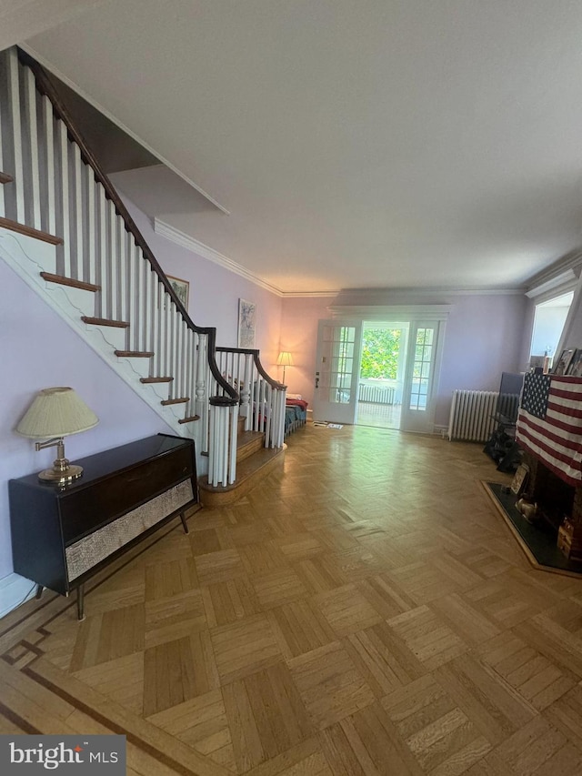 living room with radiator heating unit, crown molding, and parquet floors