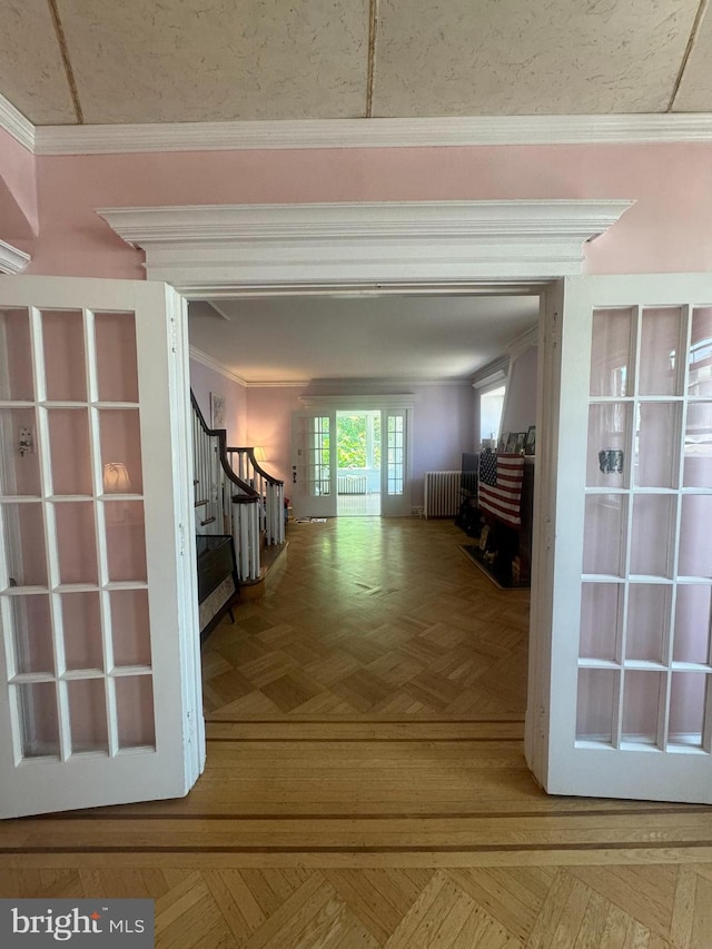 corridor featuring ornamental molding, radiator, and parquet floors