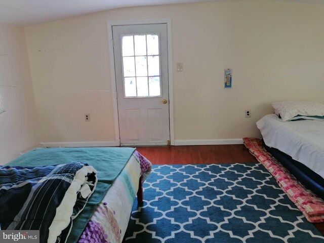 bedroom with lofted ceiling and dark wood-type flooring