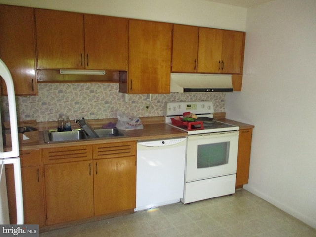 kitchen featuring tasteful backsplash, white appliances, and sink