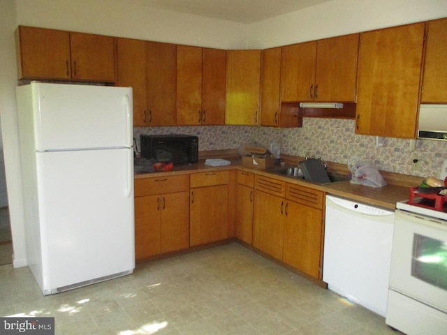 kitchen with white appliances, sink, and tasteful backsplash