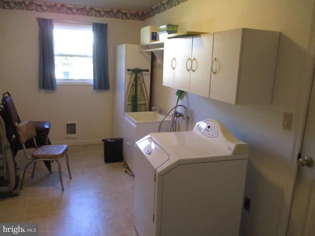 laundry room featuring cabinets and washer / dryer